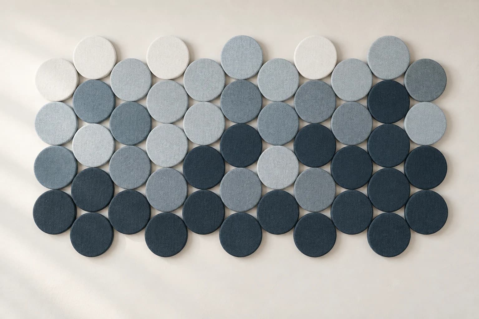Açık mavi ve gri yuvarlak kumaş panellerle oluşturulmuş duvar kompozisyonu